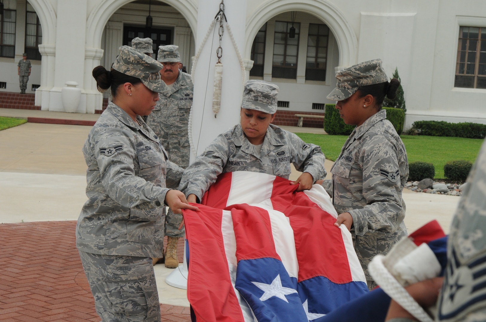Randolph AFB, TX, 11 Sep 09:  (From left to right) A1C Mary Lou Gomez, A1C Amanda Finigan and A1C Micaela Gonzalez, 12th Force Support Squadron, fold the flag during a retreat ceremony, commemorating Patriots Day.  (U.S. Air Force photo by Rich McFadden)