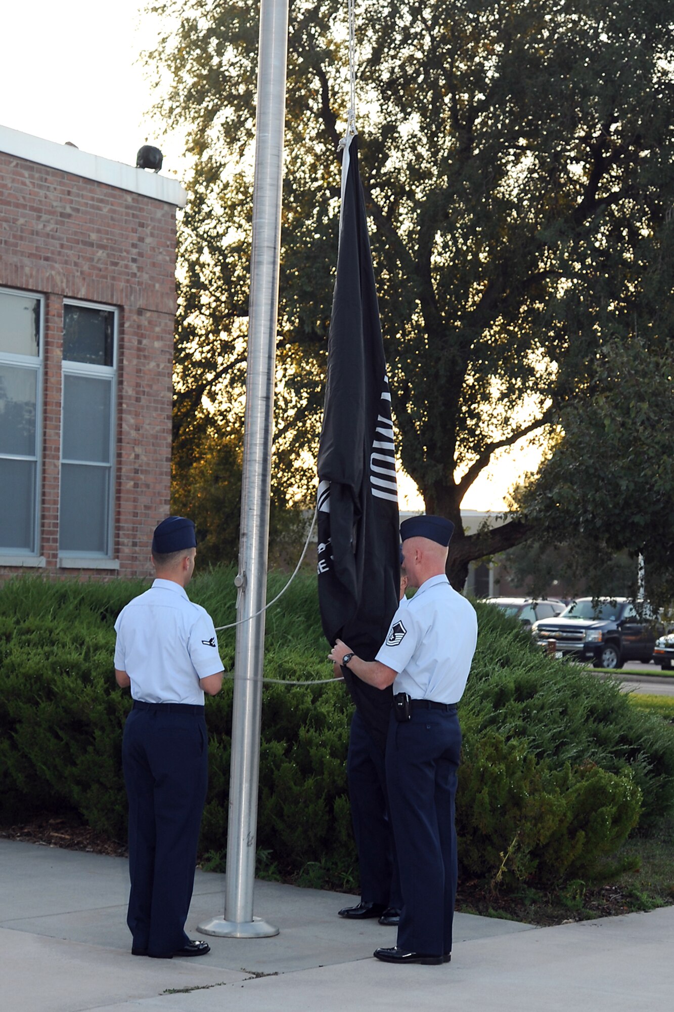 (Left to right) Airman Alberto Carrasco, 21st Operations Group, Master Sgt. William Arcuri, 21st Civil Engineer Squadron and Master Sgt. Daniel Cockrell, 21st Security Forces Squadron, raise the POW-MIA flag as part of the POW-MIA reveille ceremony Sept. 14 at the Vosler NCO Academy parade field. The 21st Space Wing will host its annual POW-MIA remembrance ceremony at 9 a.m. Sept. 18 at the chapel. The guest speaker is retired Col. Gordon Scott. Colonel Scott served as a pilot with the 78th Fighter Squadron in Hawaii and flew air to ground support missions at Iwo Jima. (Air Force photo by Roberta McDonald)