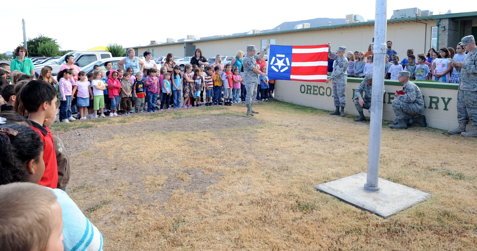 ALAMOGORDO, N.M. -- Master Sgts. Marcus and Rebecca Cooper, 49th Maintenance Squadron at Holloman Air Force Base, present a Freedom Flag to Oregon Elementary School. The Freedom Flag was created after Sept. 11 by Richard Melito and donated to all schools in the Alamogordo Public School District by the Holloman Top 3. (U.S. Air Force photo by Senior Airman Rachel Kocin)