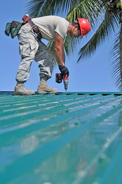 Staff Sgt. Joel Herrera-Ramos installs a metal roof on the Bel-Air School July 21, 2009, in Georgetown, Guyana, . Airmen are deployed to build the school as part of New Horizons Guyana. Sergeant Herrera-Ramos is a structural craftsman with the 555th Red Horse Squadron from Nellis Air Force Base, Nev. (U.S. Air Force photo/Airman 1st Class Perry Aston)
