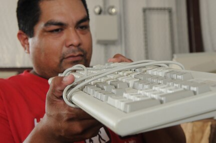 Tony Lara, 12th Civil Engineer Squadron logistics technician, examines a keyboard recently turned it to the recycle center.  The Randolph Recycle Center now accepts electronics to be recycled. (U.S. Air Force photo/Rich McFadden)