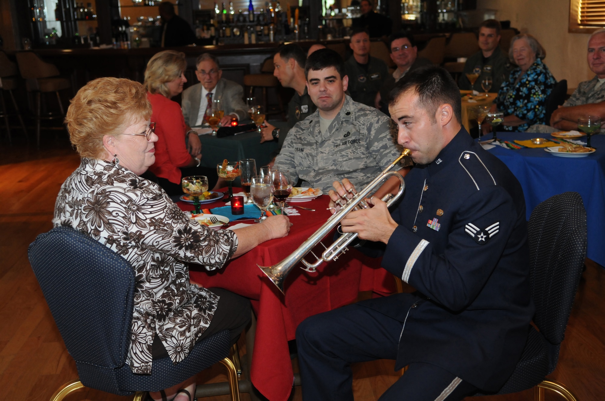 Senior Airman David Evans, a trumpet apprentice with the Gateway Band, performs a solo for one of Randolph's newest Honorary Commanders, Ms. Leslye Baumann, as Lt. Col. Christopher Crane, 12th Comptroller Squadron, looks on.  The Honorary Commanders Program enhances the positive relationship between Randolph Air Force Base and the surrounding communities. The reception was held 10 Sept, at the Randolph Air Force Base Parr Club. (U.S. Air Force photo/Melissa Peterson)
