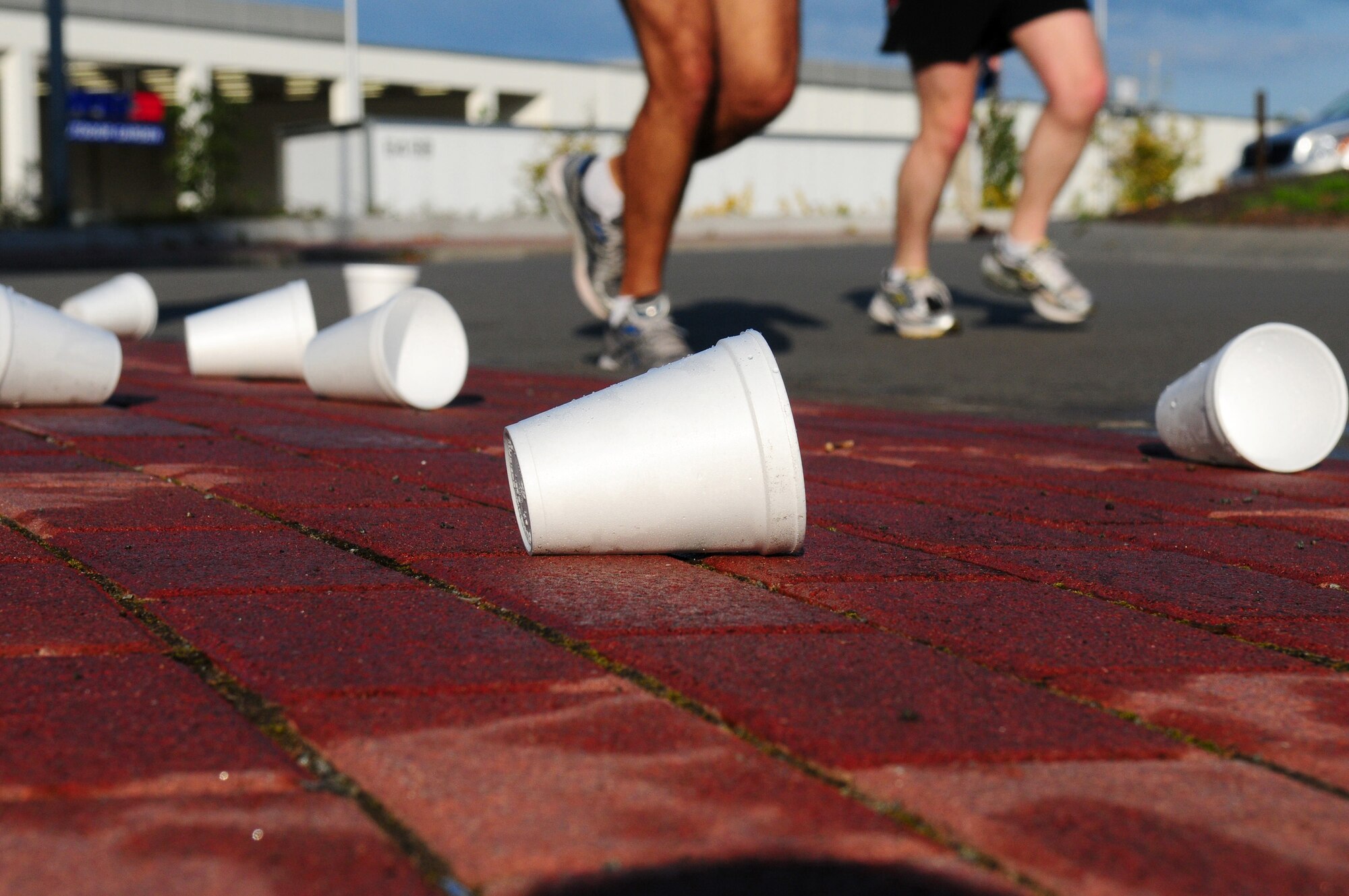 Empty cups are discarded as participants of the first ever Kaiserslautern Military Community Half Marathon race by the six-mile water station, Ramstein Air Base, Germany, Sept. 12, 2009. Members of 86th Services Squadron provided water and clean up for the 13.1-mile trek around the base.  (U.S. Air Force photo by Staff Sgt. Jocelyn Rich)