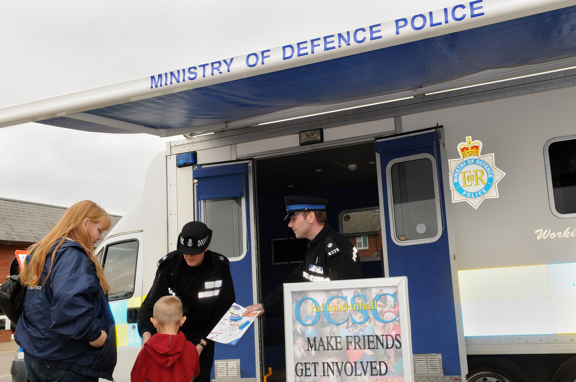 RAF MILDENHALL, England -- Police Community Service Officer Gavin Tampin (right) and Police Constable Stephanie Cochrane, Norfolk Constabulary, hand out information packets to Mollie Haag and her son Ryan, 5, Sept. 13. Seven local law enforcement agencies converged at the BXtra here for a Community Engagement Day so military members and their families could meet the policing forces that handle their home neighborhoods. The event is scheduled to be held quarterly at RAFs Mildenhall and Lakenheath, said event organizer Ministry of Defence Police Constable Paul Glover, community safety and crime reduction officer. (U.S. Air Force photo/Senior Airman Thomas Trower) 