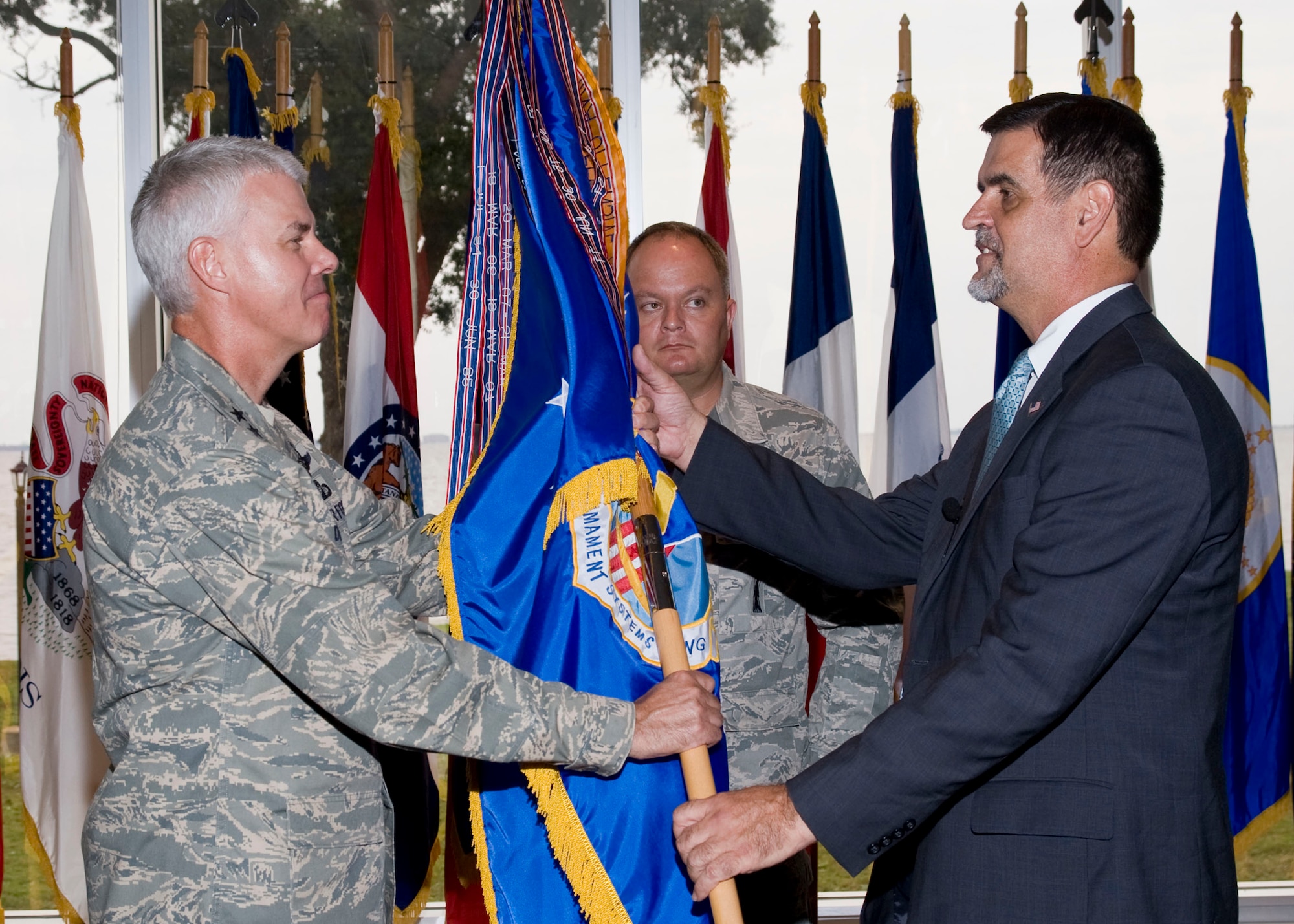 Maj. Gen. C.R. Davis, Air Armament Center, passes the 308th Armament Systems Wing guidon to Randy Brown during the appointment of directorship Sept. 11 at the officers' club.  Both General Davis and Mr. Brown took time to recognize the significance of the day and observed a moment of silence during the ceremony.  The 308th ARSW is a joint Air Force and Navy organization responsible for management of air dominance weapon system programs equipping warfighters with strike weapons.  (U.S. Air Force photo/Bruce Hoffman)  