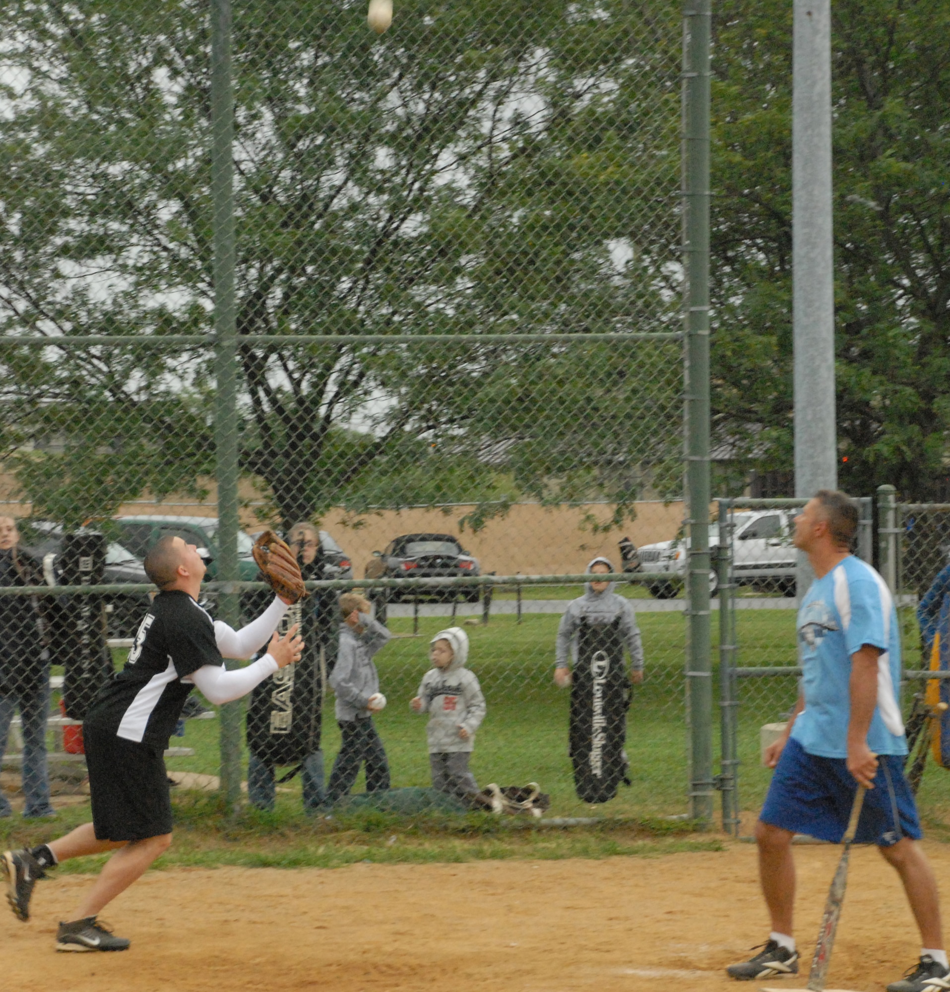 Mike Marsters, 436th Security Forces Squadron catcher, goes for a foul ball hit by Jerry Howard, 436th MXS.  (U.S. Air Force photo/Staff Sgt. Chad Padgett)