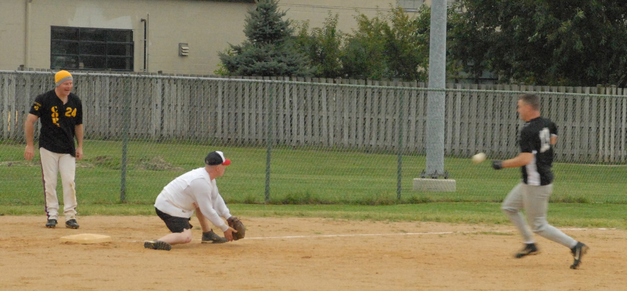 Jason Thomas races the ball to third base, as 436th Maintenance Squadron third baseman Anthony Corman attempts to stop him.  Thomas managed to slide past the third baseman and was called safe.   (U.S. Air Force photo/Staff Sgt. Chad Padgett)