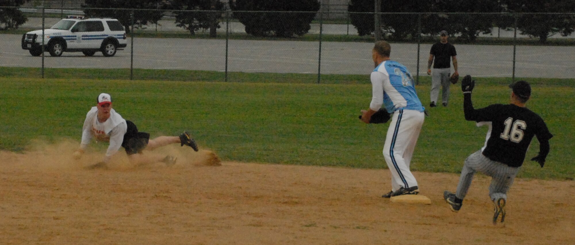 (Left) Anthony Corman makes a diving catch and throw to 436th Maintenance Squadron second baseman  Joe Mageau as Jay Keough, 436th Security Forces Squadron, slides to base.  (U.S. Air Force photo/Staff Sgt. Chad Padgett)