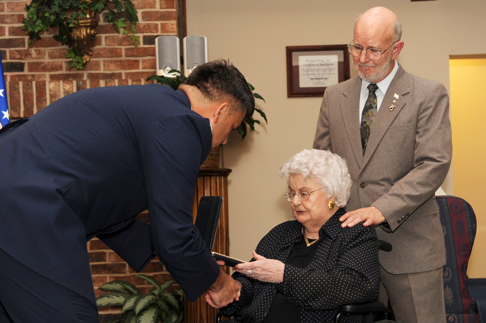 Col. Greg Otey, 19th Airlift Wing commander, presents  Louise Meroney and her son, Doug Meroney, the Prisoner of War medal on behalf of her late husband, Retired Col.  Virgil Meroney at the Trinity Village Retirement Community, Pine Bluff, Ark. Sept. 9. Colonel Meroney was captured and held as a POW in Germany during WW II for a year before escaping captivity near the Rhine River. (US Air Force photo by Senior Airman Jim Araos)