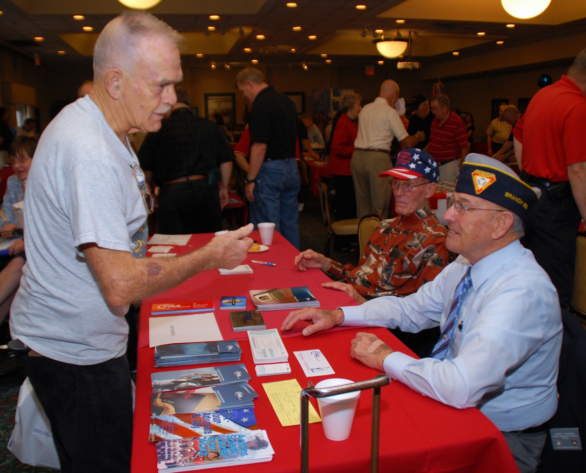 Retired Master Sgt. Jerry Hobson (right) and retired Chief Master Sgt. Silas Legrow, hand out brochures to retirees at the Fleet Reserve Association display table at the conference center during Retiree Appreciation Day, Sept. 12. Throughout the day, different vendors from around the area handed out free samples to retirees and informed them about their programs and organizations. (U.S. Air Force photo by Airman 1st Class Rochelle Clace)