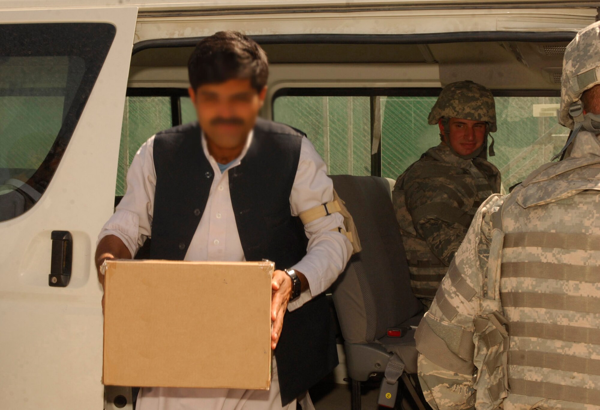 BAGRAM AIRFIELD, Afghanistan - An Afghan man transports the remains of skin and bone segmensts of six local Afghans back to the community where he lives. The remains were buried at a mosque in the town that surrounds Bagram Airfield. The Craig Joint Theater Hospital here treats any injured person, regardless of nationality, as long as they are brought to the hospital because of injuries caused by combat. (Photo illustration by Tech. Sgt. John Jung)