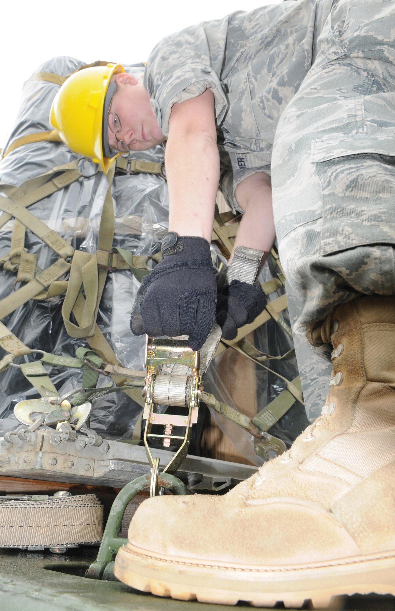 Staff Sgt. Katie Sawyer, member of the 1st Combat Communications Squadron, tightens down a cargo strap in order to securing a pallet in preparation for a vehicle convoy from Ramstein Air Base Germany to Aviano Air Base Italy.  The convoy consists of seven trucks carrying approximately 10 tons of equipment. (U.S. Air Force photo by Tech Sgt. Sean Mateo White)