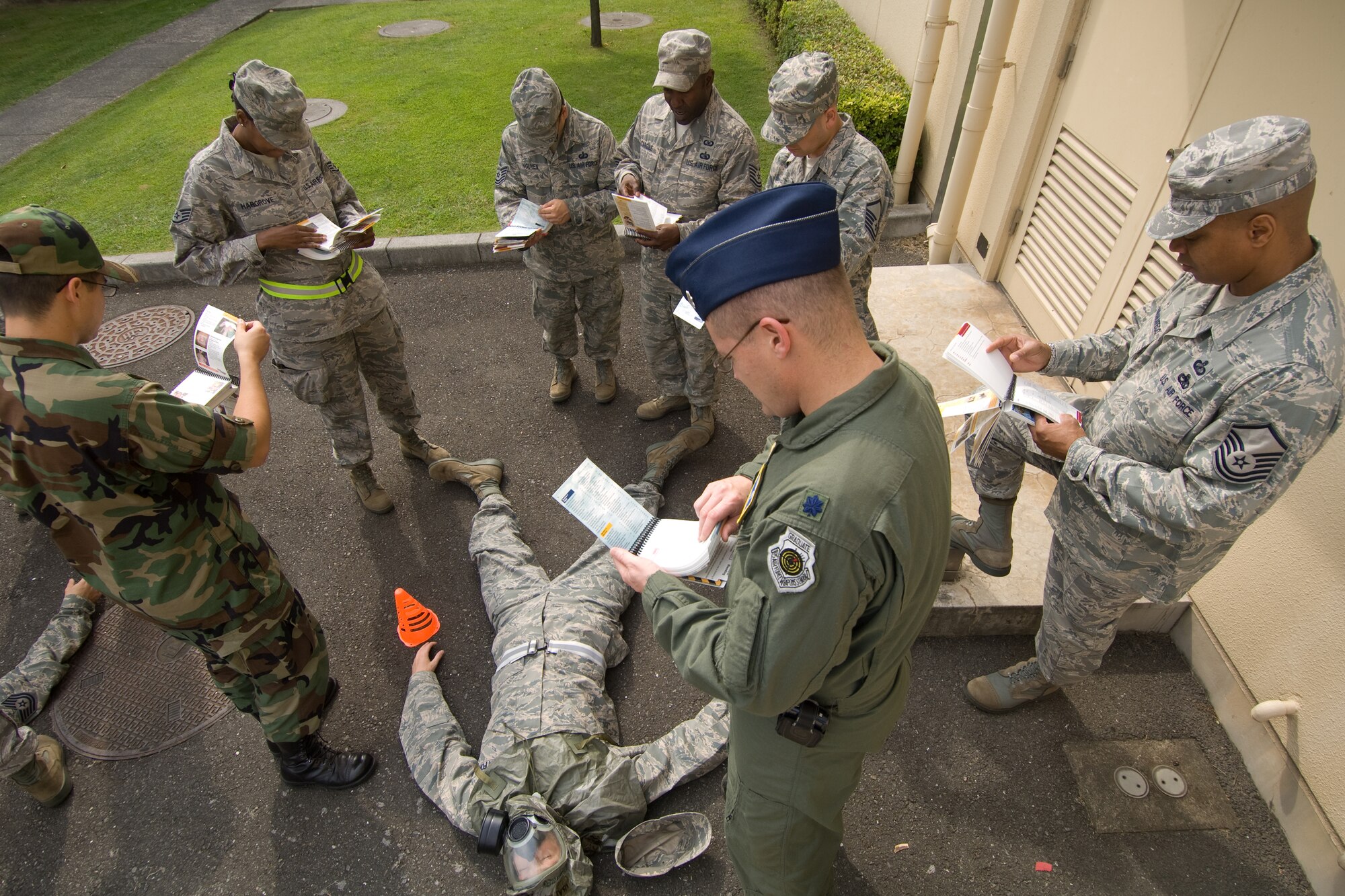 YOKOTA AIR BASE, Japan -- Members of the 374th Airlift Wing staff agencies check their Airman's Manuals for information on how to transport a simulated victim to a medical treatment facility during Ability to Survive and Operate training recently. ATSO knowledge will be an area of emphasis during the wing's upcoming Operational Readiness Inspection. (U.S. Air Force photo/Osakabe Yasuo)
