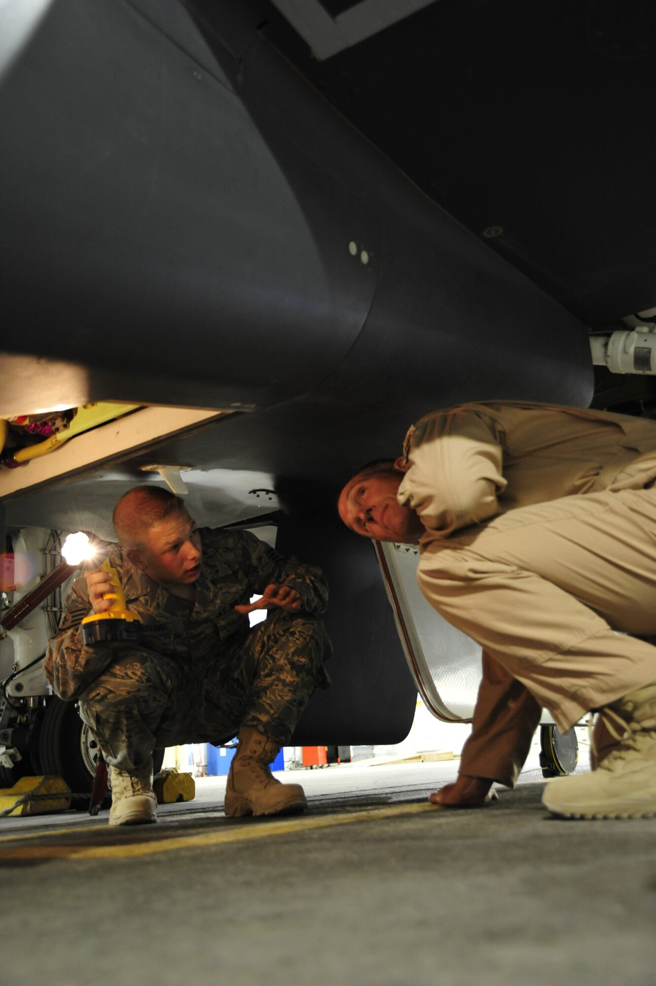 SOUTHWEST ASIA -Lt. Gen. Mike Hostage, Air Force Central Command commander, and Staff Sgt. Christopher Johnston, 380th Expeditionary Aircraft Maintenance Squadron, take a closer look underneath of a RQ-4 Global Hawk Sept. 13, 2009. General Hostage was briefed by Sergeant Johnston on the mission and capabilities of the aircraft. (U.S. Air Force photo/Tech. Sgt. Charles Larkin Sr)