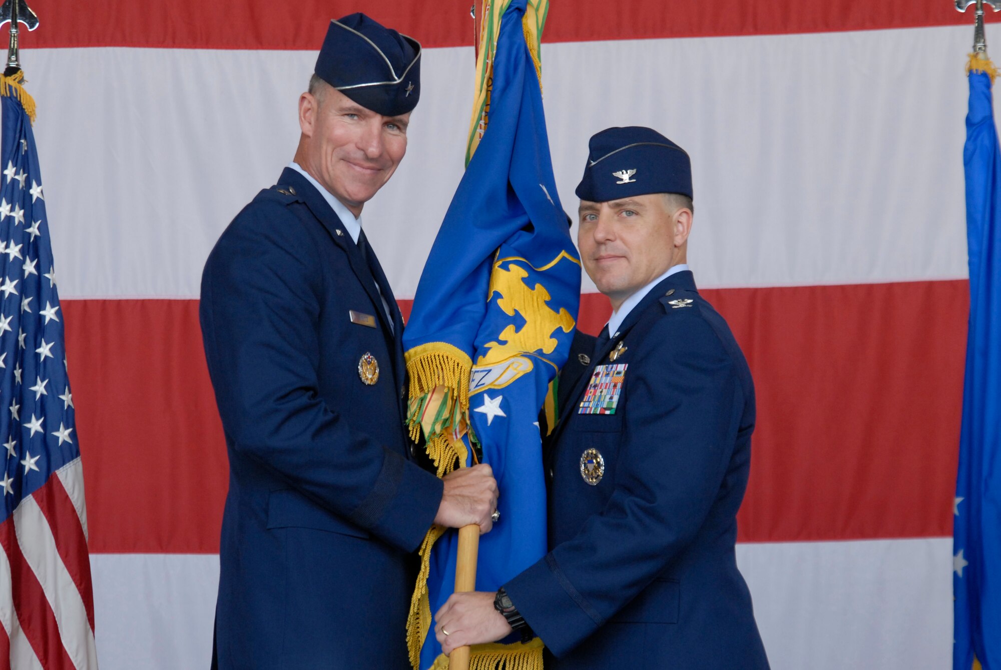 KUNSAN AIR BASE, Republic of Korea -- Brig. Gen. Michael Keltz, 7th Air Force vice commander, hands the guidon to Col. Robert Givens, 8th Fighter Wing commander, during the 8th FW Change of Command ceremony here Sept. 15. Colonel Givens is the 49th Wolf Pack commander to command the 8th Fighter Wing. (U.S. Air Force photo/Staff Sgt. Darnell T. Cannady)