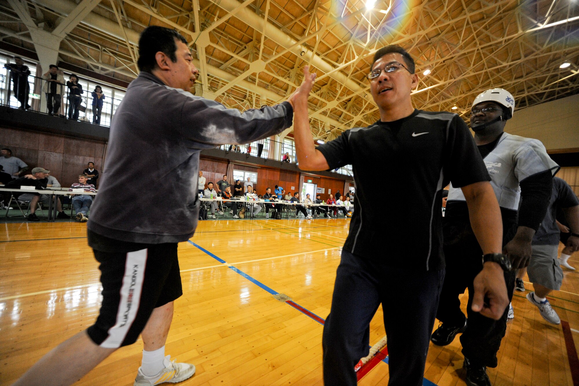 MISAWA AIR BASE, Japan -- The 35th Communications Squadron’s Comm Rockers congratulate the Black Panthers after a match during the Misawa Air Base Tug-of-war Tournament Sept. 12. Despite the competitive nature of the event, all teams showed respect to each other by bowing and shaking hands after each match. (U.S. Air Force photo/Senior Airman Jamal D. Sutter)
