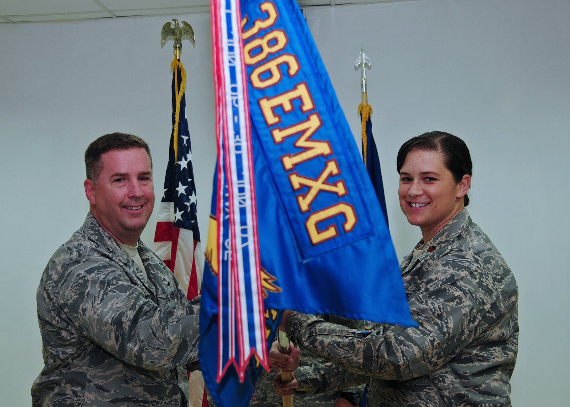 SOUTHWEST ASIA -- Maj. Erika Kelley assumes command of the 386th Expeditionary Maintenance Squadron, by accepting the guidon from Col. Andrew Molnar, 386th Expeditionary Maintenance Group commander, during a change of command ceremony at an air base in Southwest Asia Sept. 14, 2009.  (U.S. Air Force photo/Tech. Sgt. Tony Tolley)