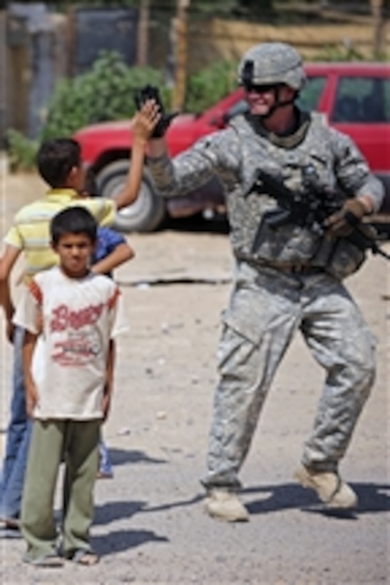 U.S. Army Sgt. Juan Reyes high-fives an Iraqi boy while providing security in Sequor, Iraq, on Sept. 9, 2009.  Reyes is from the security detachment of 25th Special Troops Battalion, 25th Infantry Division.  