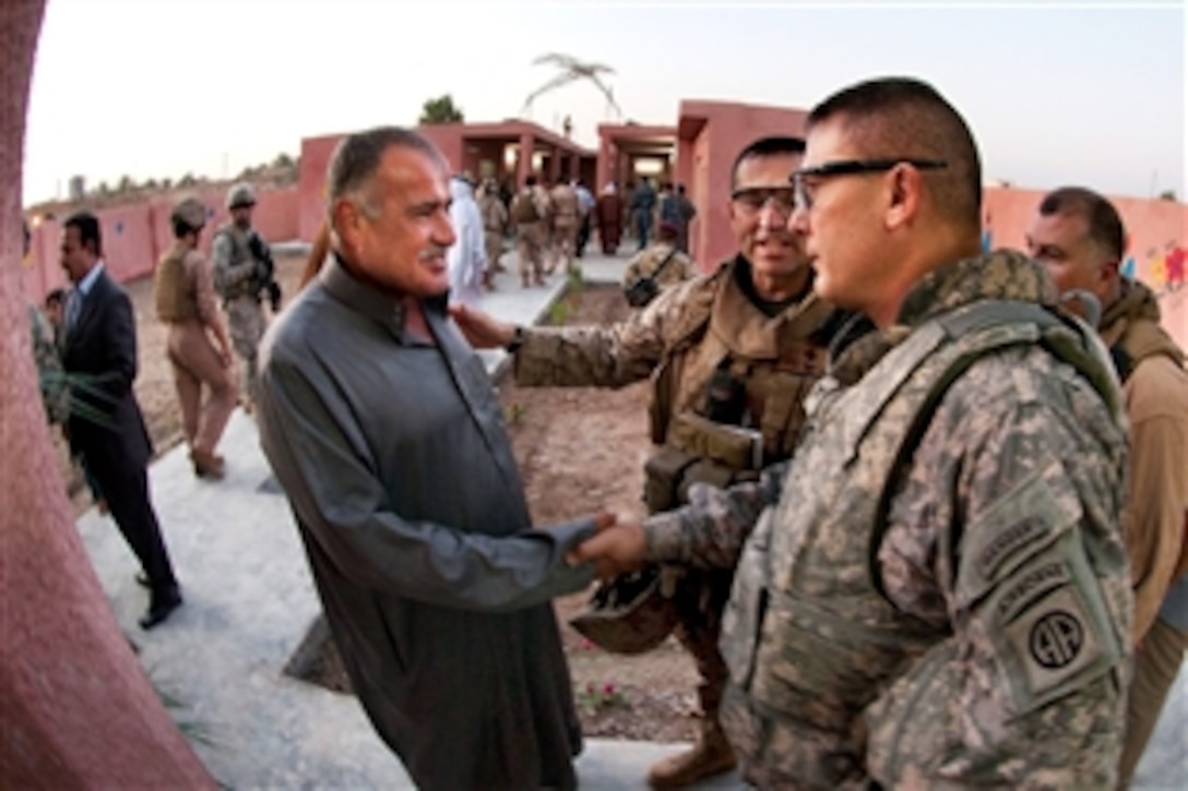 U.S. Marine Corps Col. Matthew Lopez, center, introduces the Karmah education inspector to Army Col. Mark Stammer at the opening of the Karmah School for Girls in Karmah, Iraq, Sept. 9, 2009. Stammer’s brigade of paratroopers will continue the Marines’ partnerships with Iraqi security forces, sheiks, and local and provincial officials to ensure that school and water projects continue. 