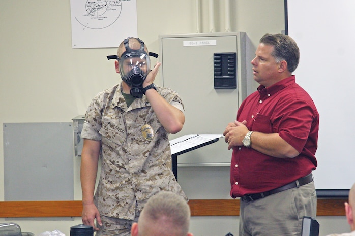Lance Cpl. Andre Pawlowski demonstrates how to clear the new Millennium masks during the chemical biological radiological and nuclear awareness and operations training held at the Provost Marshal’s Office here Sept. 15.