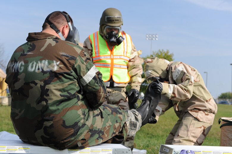 WHITEMAN AIR FORCE BASE, Mo. – Senior Airman Melissa Miller, 442nd Fighter Wing, takes off her partner, Staff Sergeant Jonathon Gray, chemical boot while processing through a chemical line during an exercise, Sept. 16. The 442nd Fighter Wing has exercise to ensure their members remain current on their readiness training. (U.S. Air Force Photo/ SrA Cory Todd)