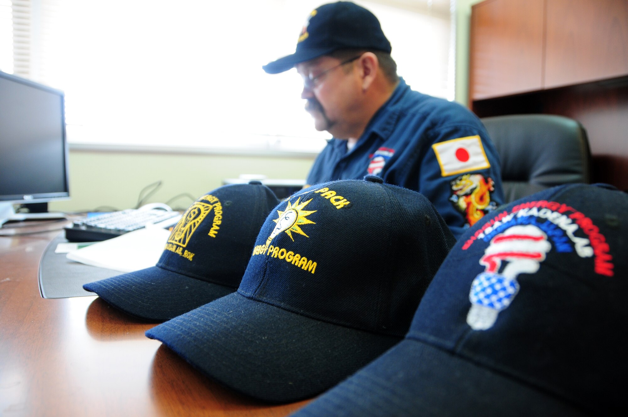 John Muckey, a resource efficiency manager for the 718th Civil Engineer Squadron at Kadena Air Base, Japan, looks over analytical charts on energy conservation.  Mr. Muckey, known around the base as "Energy Guy," was a key part of the team effort that resulted in the base earning the 2009 Federal Energy and Water Management Award. (U.S. Air Force photo/Staff Sgt. Lakisha A. Croley)