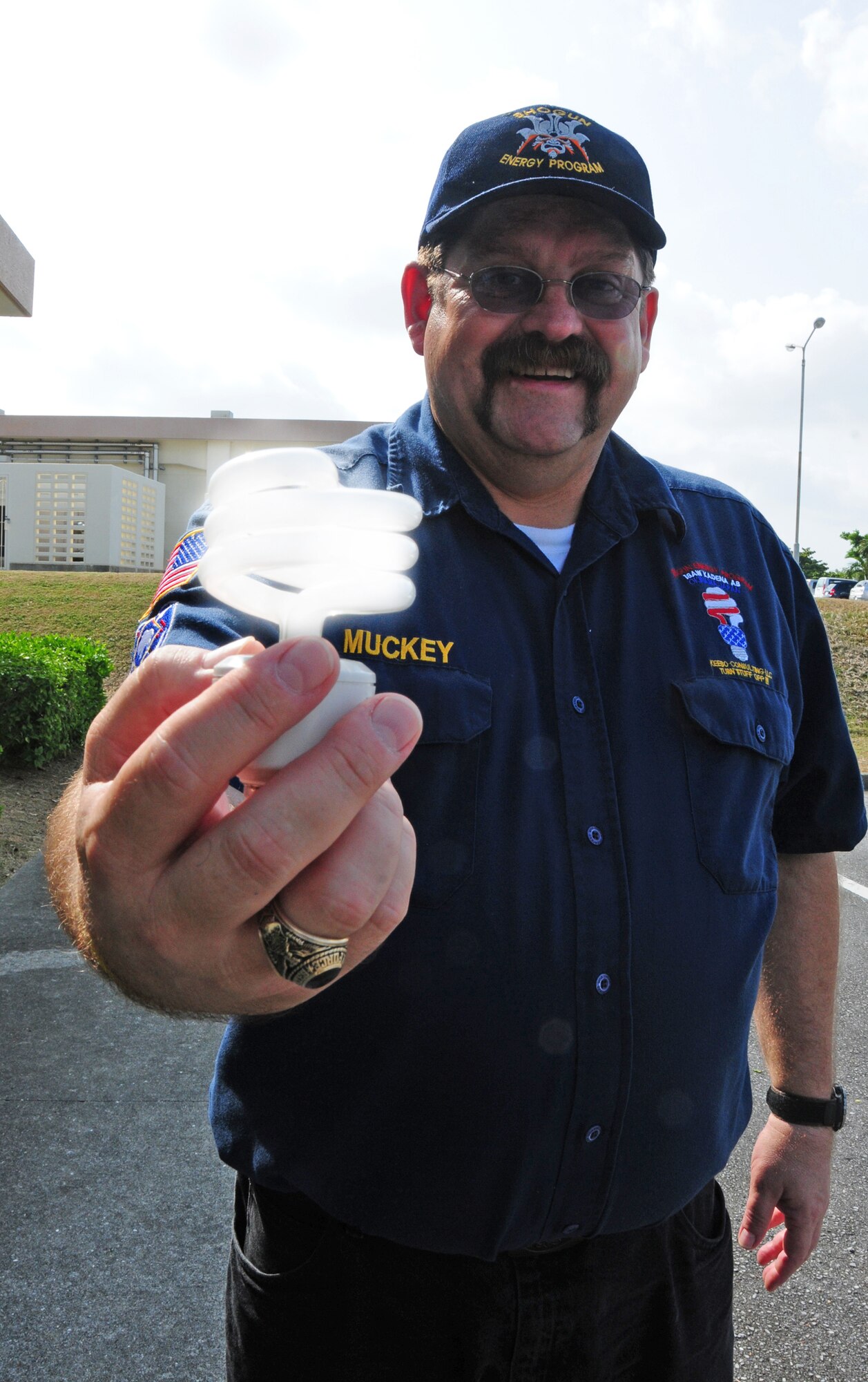 John Muckey, a resource efficiency manager for the 718th Civil Engineer Squadron at Kadena Air Base, Japan, reveals one of the resources, an energy-saving light bulb, that helped the base earn the 2009 Federal Energy and Water Management Award. Mr. Muckey is known around the base as "Energy Guy."  (U.S. Air Force photo/Staff Sgt. Lakisha A. Croley)