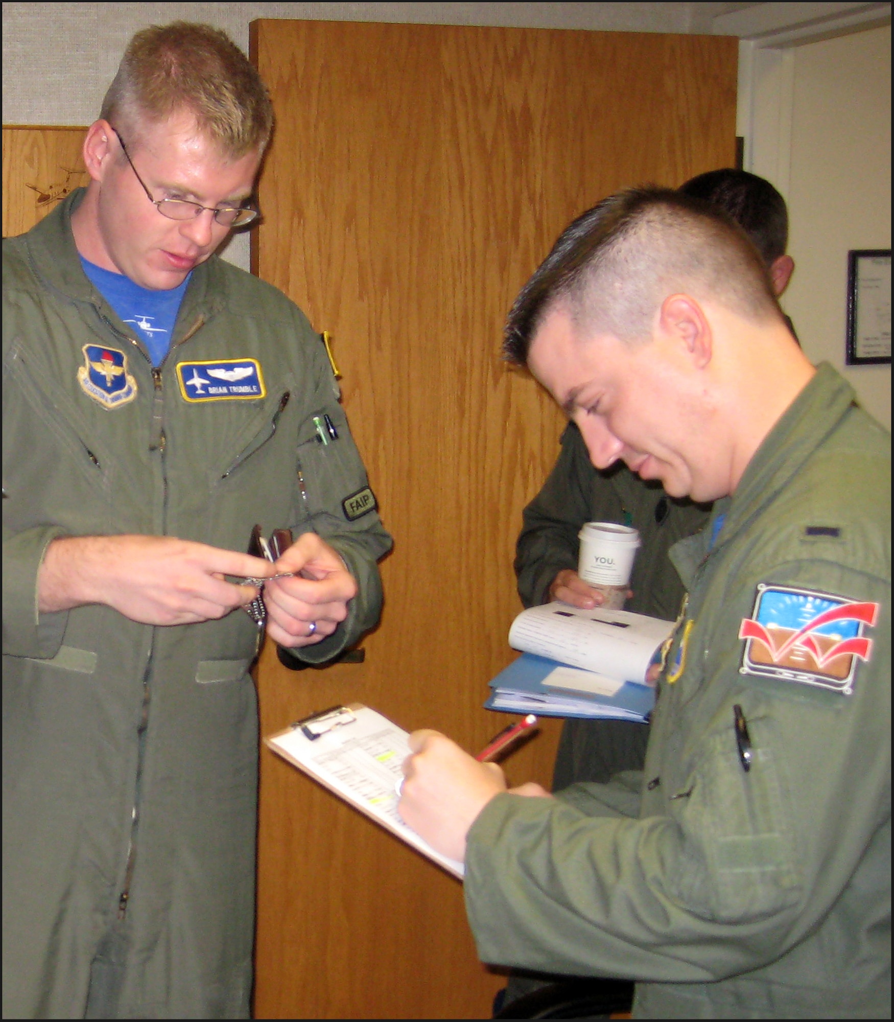 First Lt. Jarrod Judd, left, checks the I.D. card and dog tags of Capt. Brian Trumble before the 32nd Flying Training Squadron deploys to the Combat Readiness Training Center in Alpena, Mich., Aug. 21-24. The squadron participated in air-refueling and precision landings during the deployment. (Photo/ Capt. Anthony Cannone)