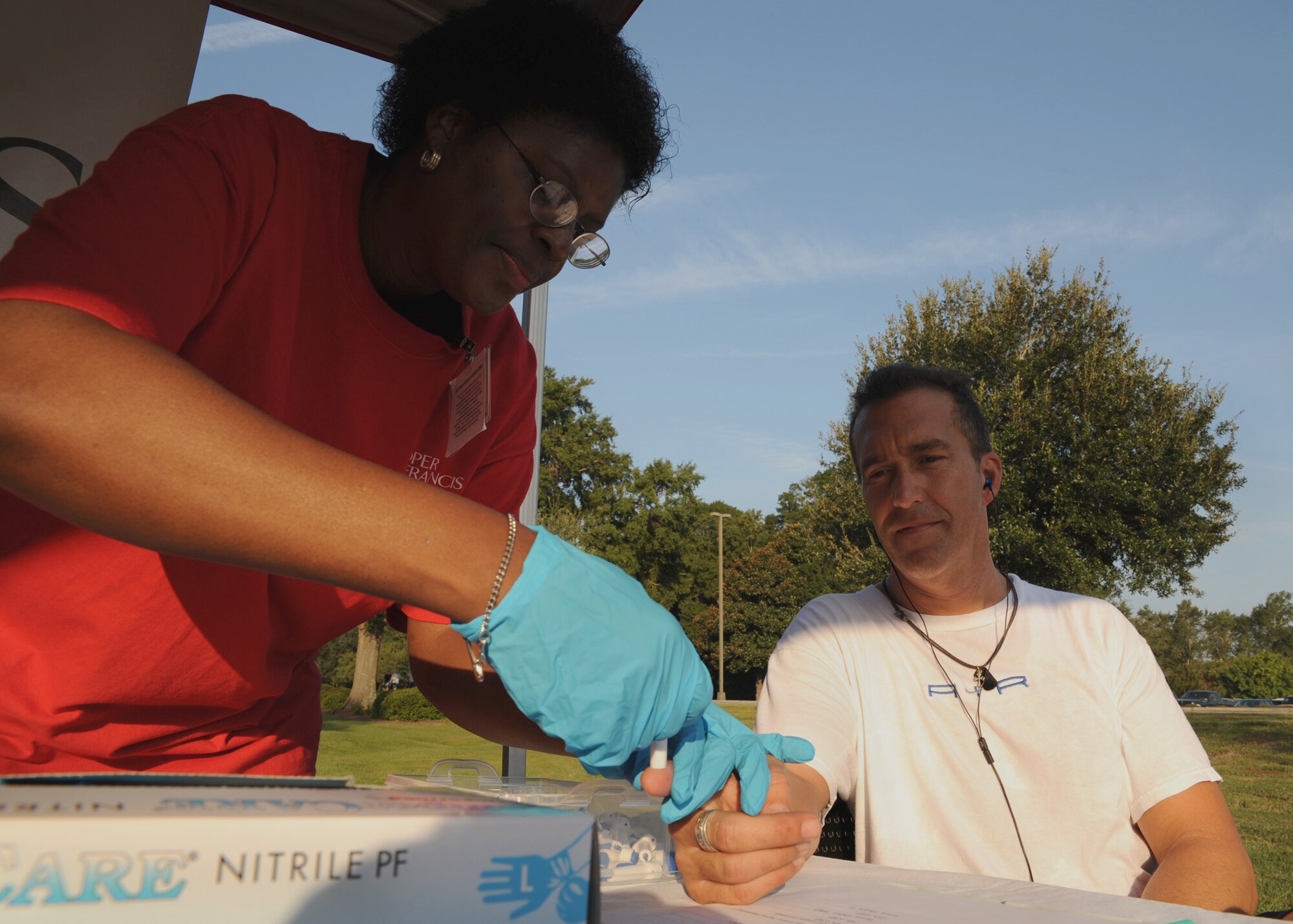 Traci Ray tests Randy Munroes blood glucose level after the Commander's 5K Run/Walk Challenge here Sept. 11. Sponsors from different companies in the local area came out to support Team Charleston at the Fitness and Sports Center during the event. Ray is a registered nurse with Roper St. Francis hospital and Munroe is a standardization and evaluation chief with the 317th Airlift Squadron. (U.S. Air Force photo/Senior Airman Katie Gieratz)(RELEASED)