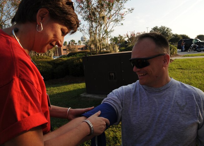 Judy Burbage checks Evan East's blood pressure after the Commander's 5K Run/Walk Challenge here Sept. 11. Local volunteers from Roper St. Francis hospital volunteered to assist members of Team Charleston in checking up on their health as part of the day's event. Burbage is a nurse at Roper St. Francis hospital and East is a safety program integration officer with the 437th Airlift Wing safety office. (U.S. Air Force photo/Senior Airman Katie Gieratz)(RELEASED)