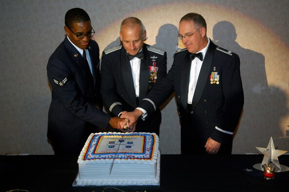 MINOT AIR FORCE BASE, N.D. -- Airman 1st Class Tony Gross, 5th Maintenance Squadron aerospace ground equipment apprentice, Maj. Gen. James M. Kowalski, Air Force Global Strike Command vice commander, and Lt. Col. Leo Shockley, 5th Medical Group dental flight commander cut into a ceremonial cake in honor of the 62nd birthday of the Air Force during the Air Force Ball here, Sept. 12. It is tradition that the first cut in the cake is made by the youngest Airman and the oldest Airman in attendance, along with the guest speaker. (U.S. Air Force photo by Airman 1st Class Jesse Lopez)
