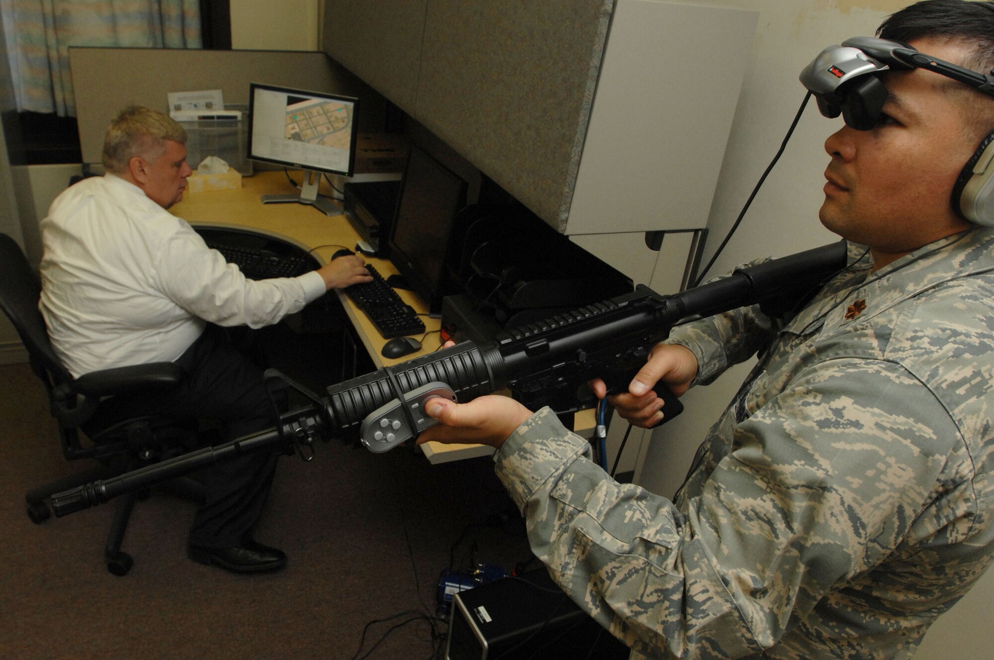 Dr. Alan Maiers (left), assistant chief, Warrior Resiliancy Program, simulates a virtual reality city patrol for Maj. Monty Baker, director of research, Warrior Resiliancy Program, Aug. 26 at Wilford Hall Medical Center, Lackland Air Force Base, Texas. The virtual reality program is designed to treat servicemembers who suffer from post traumatic stress disorder after returning from combat operations. (U.S. Air Force photo by Senior Airman Amber Bressler)
