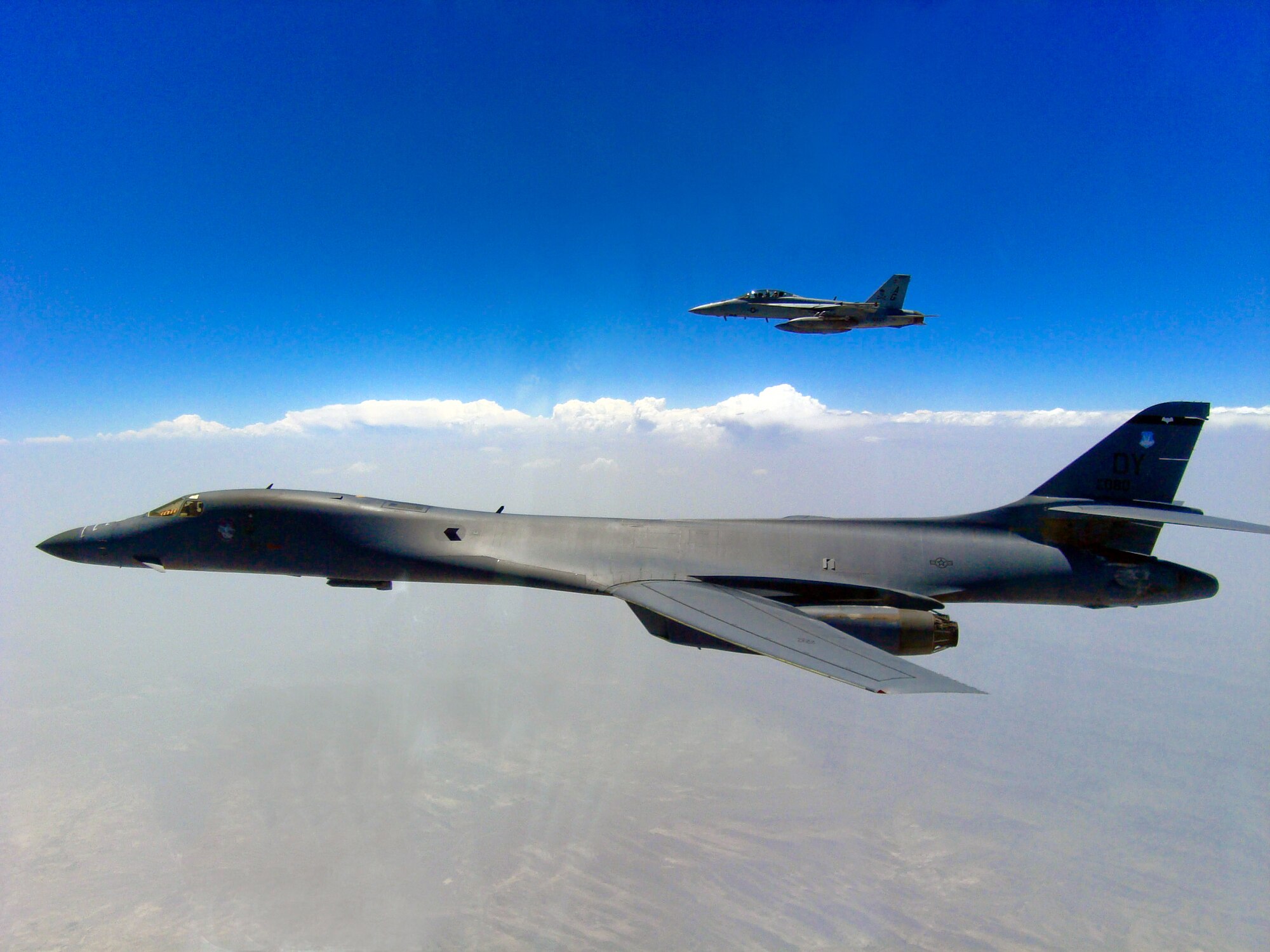 An F/A-18F Super Hornet flies alongside a B-1B Lancer after a close-air-support mission supporting coalition forces in Afghanistan.  (U.S. Navy photo/Lt. Marques Jackson)