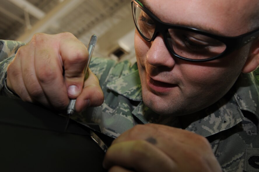 Staff Sgt. Andrew Holder, 22nd Maintenance Squadron Fabrication Flight, uses a knife to size leading edge tape on a ruddevator, Sept. 14, 2009, at McConnell Air Force Base, Kan.  Ruddevators are attached to cylindrical beams called booms that KC-135 Stratotankers use to pass fuel to other aircraft. They are a pair of independently functioning fins that allow boom operators to maneuver the boom. The tape protects ruddevators from impact and corrosion and extends their serviceability. (U.S. Air Force photo/Tech. Sgt. Chyrece Campbell)