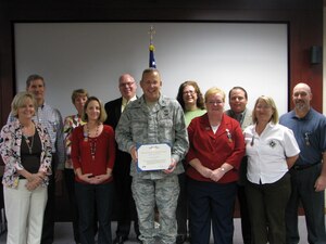 Col. Dan Johnson, commander, 480th Intelligence, Surveillance and Reconnaissance Wing, holds the exemplary civilian service award he presented to members of the wing transition team.   The team ensured a seamless transition when the wing was reassigned from Air Combat Command, Langley Air Force Base, Va. to the Air Force Intelligence, Surveillance and Reconnaissance Agency, Lackland Air Force Base, Texas.   (U.S. Air Force photo by SMSgt Sonya Blocker)