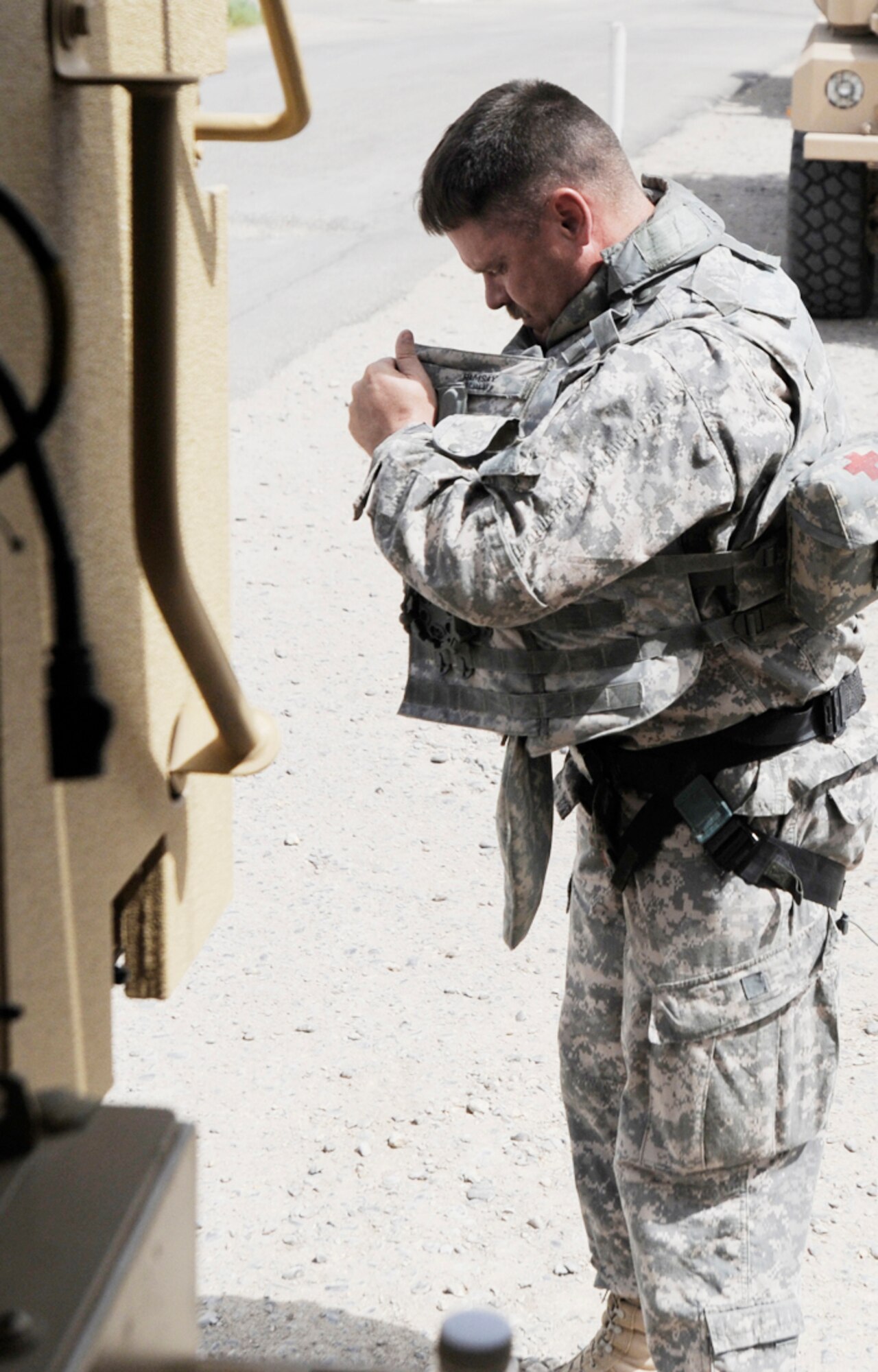 Lieutenant Colonel Steven Ramsay dons a harness in preparation for a convoy to COB Adder from Camp Ur. (U.S. Air Force photo by Staff Sgt. Shawn Weismiller)