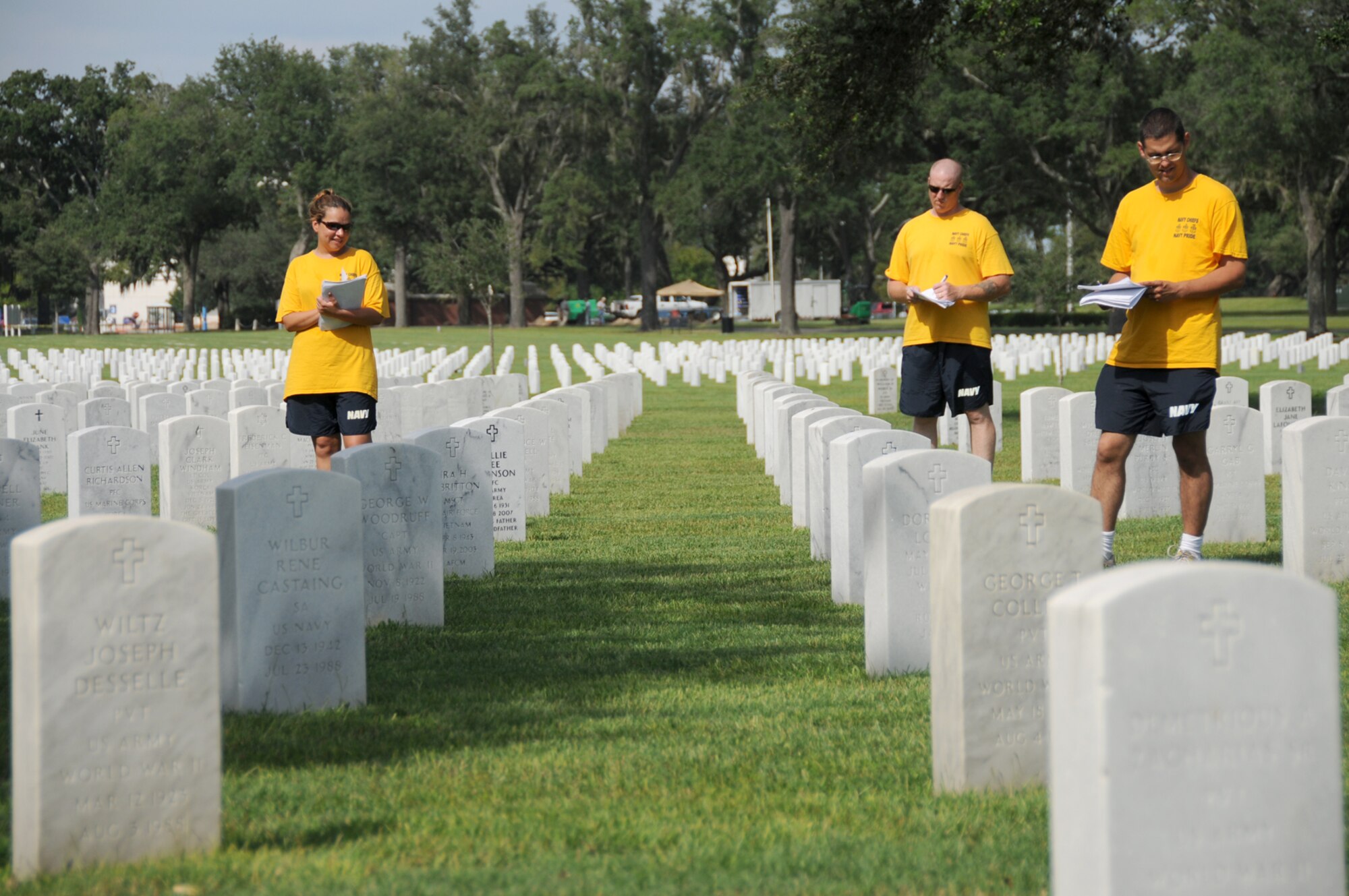 From left, Petty Officers 1st Class Carla Murray, Charles Osborne and Mathew Collier work on a grave verification detail to assist the staff at the Biloxi National Cemetery, Sept. 9.  As part of a 200-year-old Navy tradition, Sailors selected for the rank of chief petty officer go through a six-week period of training about policies, traditions and regulations, in addition to performing community service.  (U.S. Air Force photo by Kemberly Groue)