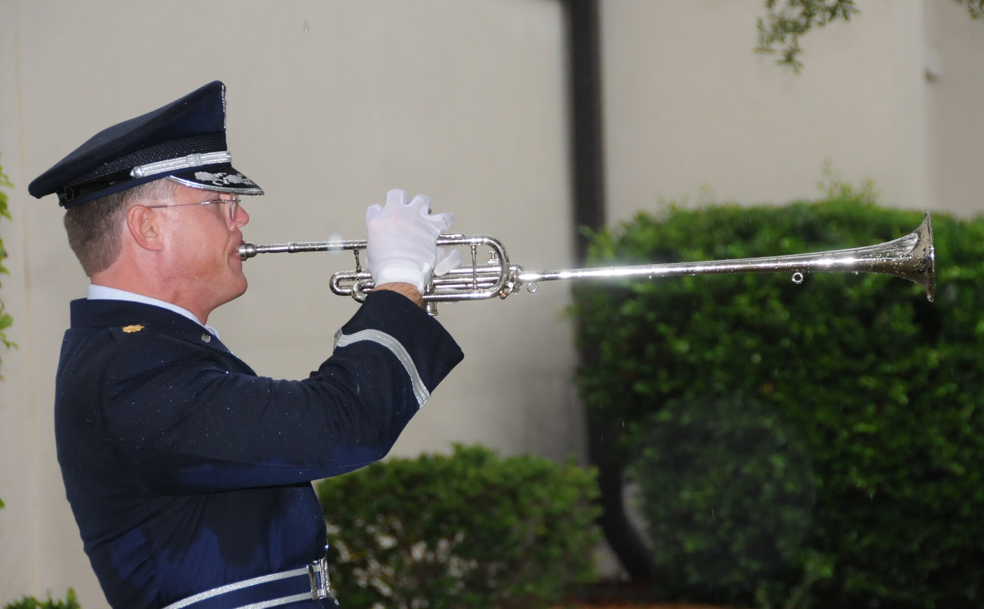 Maj. Michael Wascher plays Taps on the herald trumpet at the 9/11 retreat ceremony in front of 81st Training Wing headquarters.  Many base members braved an afternoon downpour to attend.  (U.S. Air Force photo by Kemberly Groue)