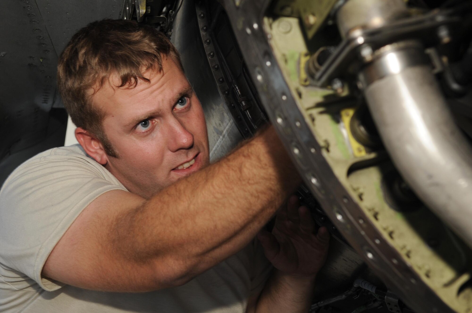 SHAW AIR FORCE BASE, S.C. -- Staff Sgt. Todd Steele, 20th Aircraft Maintenance Squadron crew chief, works on an F- 16 as he tries to loosen a part from the jet Sept. 9. Shaw maintainers and the depot field team from Hill Air Force Base, Utah, work together to accomplish the new modification of the F-16.  The beyond-line-of-sight satellite communication radios being installed allow the F-16 to utilize satellite communications to talk with units outside line-of-sight. The end result is a greatly extended range of communication. (US Air Force Photo/Senior Airman David Minor) 