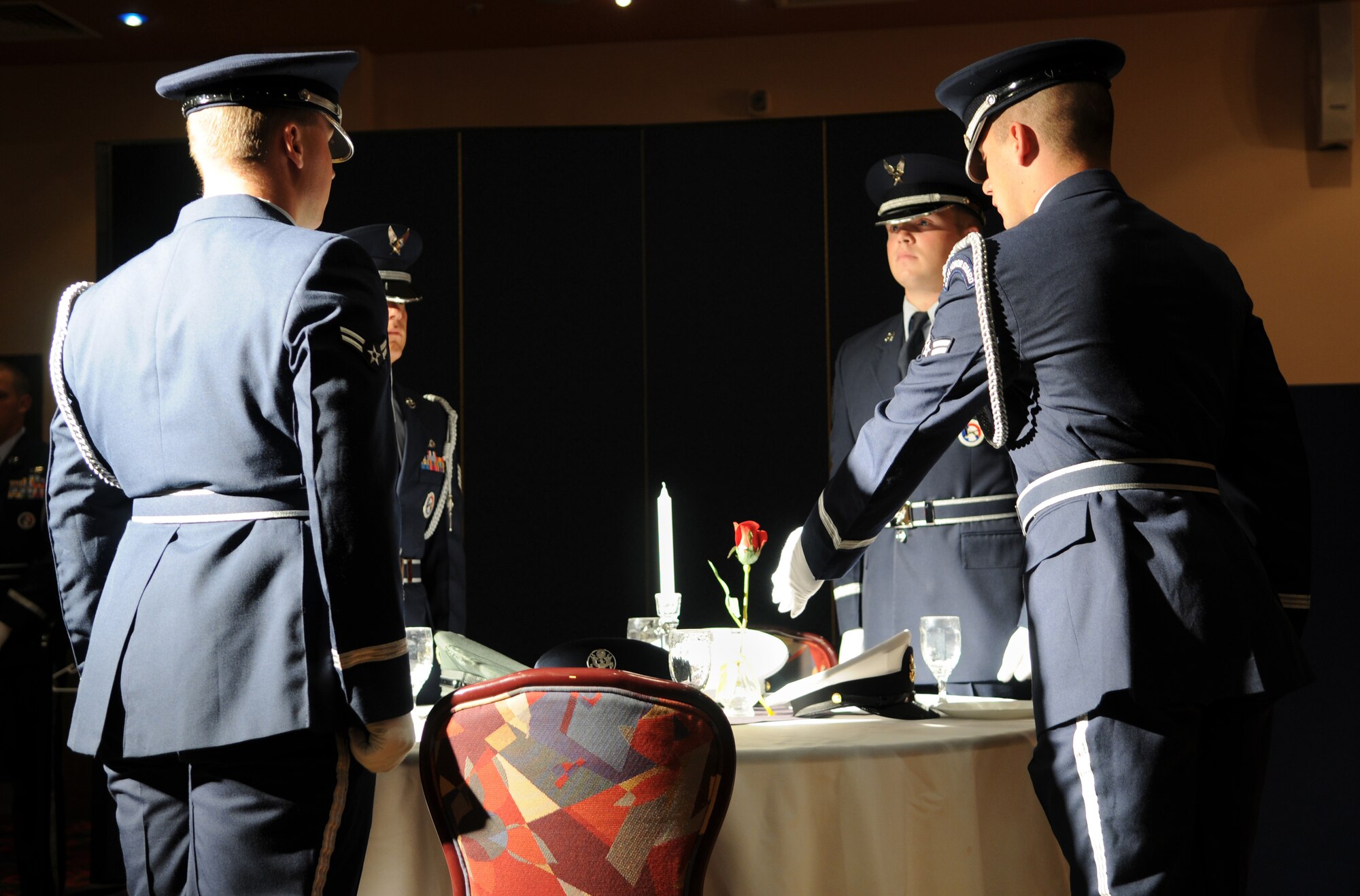 RAF MILDENHALL, England -- Members of the RAF Mildenhall Honor Guard perform the missing man table ceremony at the Prisoner of War/Missing in Action Remembrance Luncheon at the Galaxy Club here Sept. 16. During the luncheon, two former Royal Air Force servicemembers, as guest speakers, recounted the events of their capture and detention in Germany during World War II. (U.S. Air Force photo/Senior Airman Thomas Trower)