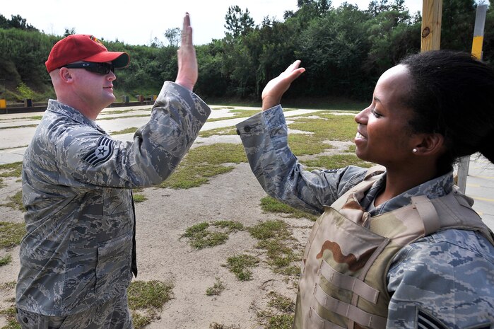 Staff Sgt. Anthony Waldon gives Senior Airman Tremaine Wright-Aklin a high-five after she qualified on the M-16A2 rifle at Naval Weapons Station Charleston, S.C., Sept. 10. Airmen are required to qualify at the course if issued an M-16A2 rifle for a deployment and for periodic evaluations. Sergeant Waldon is a combat arms instructor with the 437th Security Forces Squadron and Airman Wright-Aklin is a readiness spare package specialist with the 437th Logistics Readiness Squadron. (U.S. Air Force photo/ James M. Bowman)