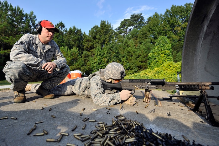 Staff Sgt. Shaun Ferguson evaluates Senior Airman Jonathan Garrett while he shoots a M-240 machine gun at Charleston AFB Sept. 10. The 437th Security Forces Squadron combat arms instructors are responsible for inspecting and maintaining more than 6,000 weapons annually to support combat arms training. Sergeant Ferguson is a combat arms instructor and Airman Garrett is a security forces member. (U.S. Air Force photo/ James M. Bowman)