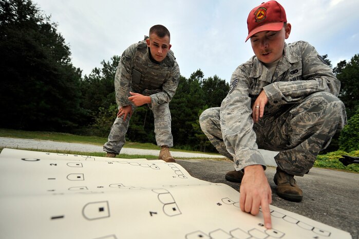 Staff Sgt. Shaun Ferguson explains target engagement tactics with Senior Airman Jonathan Garrett prior to shooting an M-249 automatic rifle at Charleston AFB Sept. 10. The 437th Security Forces Squadron's combat arms instructors train more than 3,200 students on 10 different weapons systems. Sergeant Ferguson is a combat arms instructor and Airman Garrett is a security forces member. (U.S. Air Force photo/James M. Bowman)
