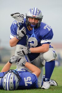 Ro-Hawks tackle Liam Murphy helps a teammate stretch during pregame warm-ups of their first home game Friday September 11, 2009. (U.S. Air Force photo/Steve Thurow)