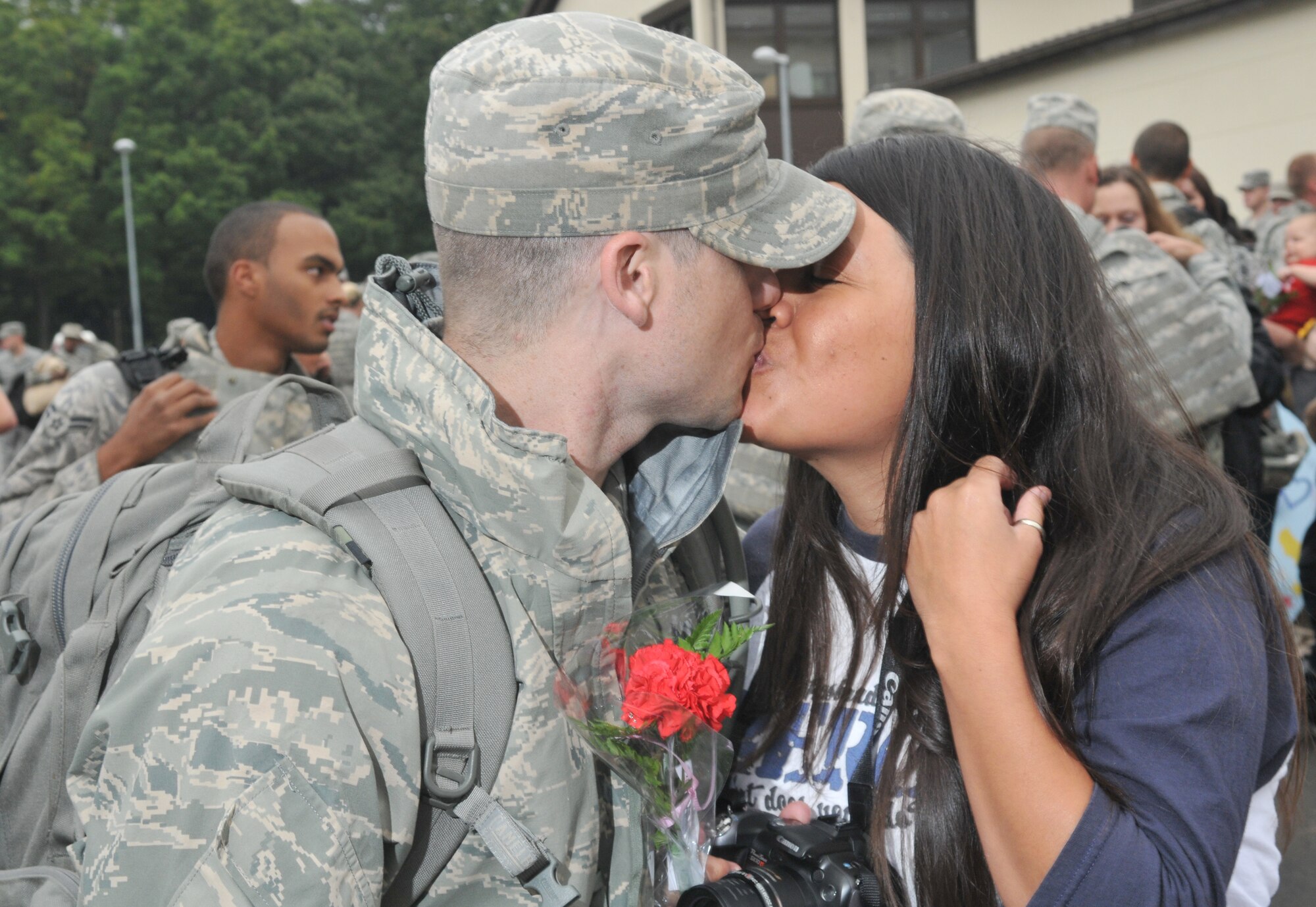 SPANGDAHLEM AIR BASE, Germany – Staff Sgt. Daniel Hawkins, 606th Air Control Squadron, kisses his wife Jessica after returning from a four-month deployment to Kandahar, Afghanistan, Sept. 16.  About 60 members of the 606th ACS operated radar and communication for command and control for the 71st Expeditionary Air Control Squadron.  The unit also deployed 300 short tons of equipment to support air battle management operations and more than 13,000 sorties.  Approximately 30 other 606th ACS members also returned from a four-month deployment to southwest Asia in support of the 73rd EACS.  (U.S. Air Force photo/Airman 1st Class Nick Wilson)
