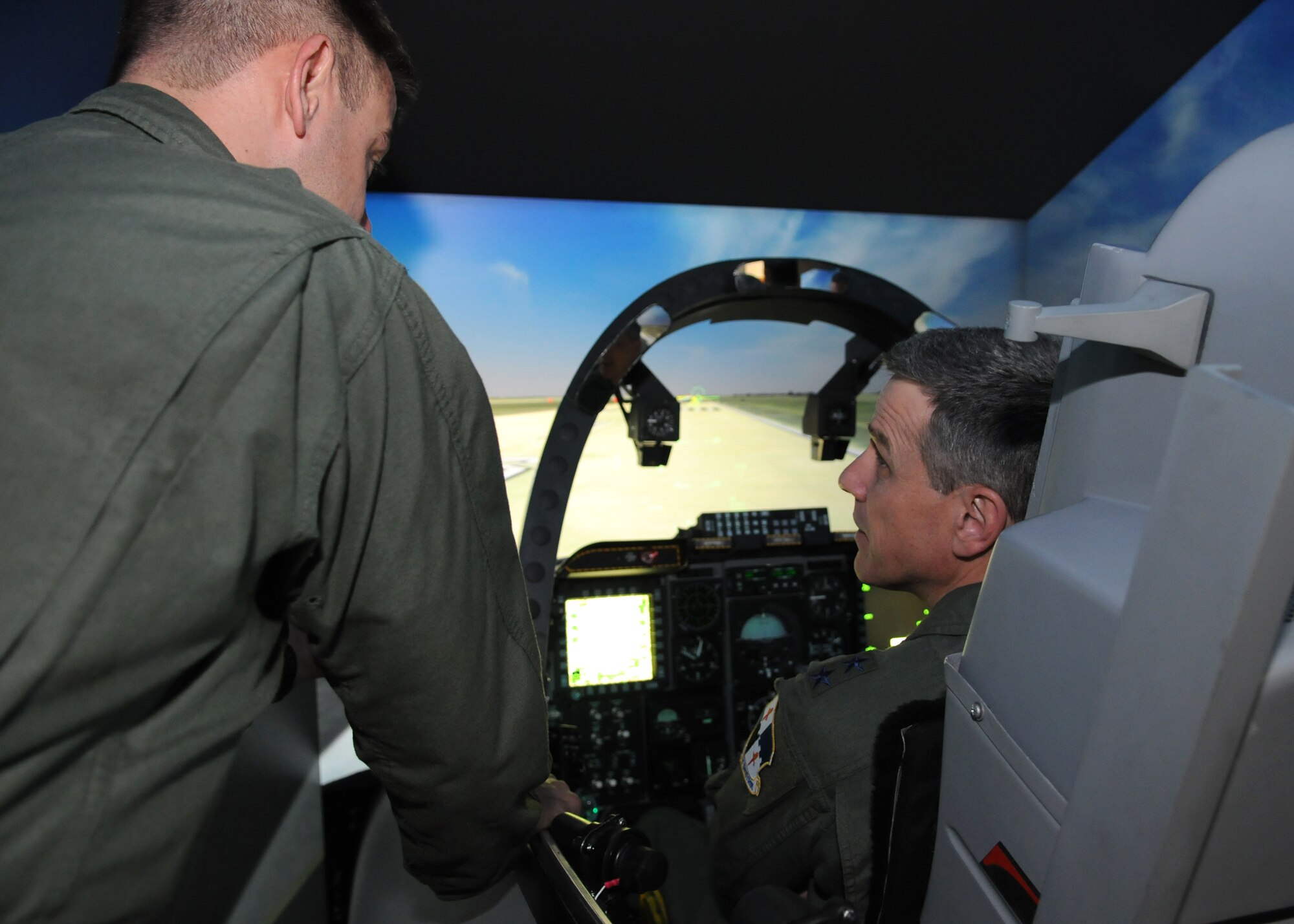 SPANGDAHLEM AIR BASE, Germany -- Lt. Col. David Trucksa, 81st Fighter Squadron, and Maj. Gen. William Chambers, U.S. Air Forces in Europe vice commander, discuss the challenges of flying an A-10 Thunderbolt II simulator Sept. 15. General Chambers toured the 81st FS and other units on base to better understand the mission of the 52nd Fighter Wing. (U.S. Air Force photo/Airman 1st Class Nathanael Callon)