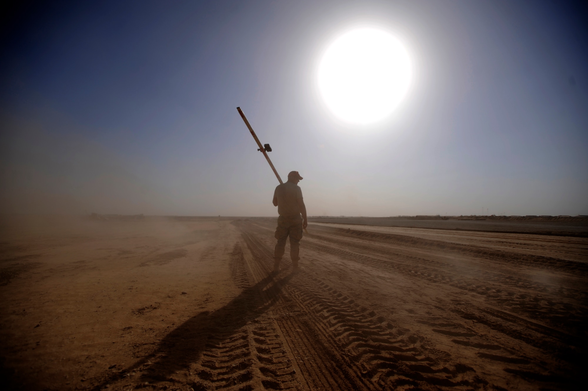 FOB DWYER, Afghanistan - Airman 1st Class Davis Smith, assigned to the 809th Expeditionary Red Horse Squadron, 1st Expeditionary Red Horse Group, carries a guide used in airfield construction Sept. 9, 2009, at Forward Operating Base Dwyer, Afghanistan. Airman Smith is a vehicle operator for the airfield construction on FOB Dwyer that will allow C-17 Globemaster III's to deliver cargo and personnel directly to the FOB. Airman Smith is deployed from the 819th Red Horse Squadron, Malmstrom, Air Force Base, Mont.  (U.S. Air Force Photo/Staff Sgt. Shawn Weismiller)