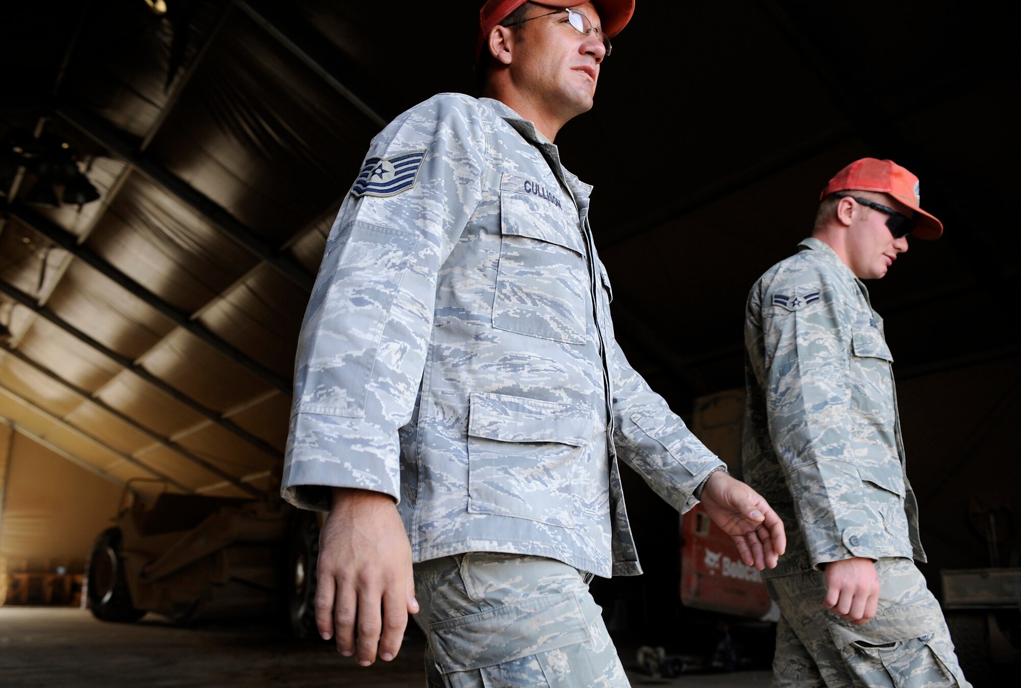 Airmen assigned to the 809th Expeditionary Red Horse Squadron, 1st Expeditionary Red Horse Group, walk out of the vehicle maintenance hanger after a morning briefing Sept. 9, Foward Operating Base Dwyer, Afghanistan. (U.S. Air Force Photo/Staff Sgt. Shawn Weismiller)