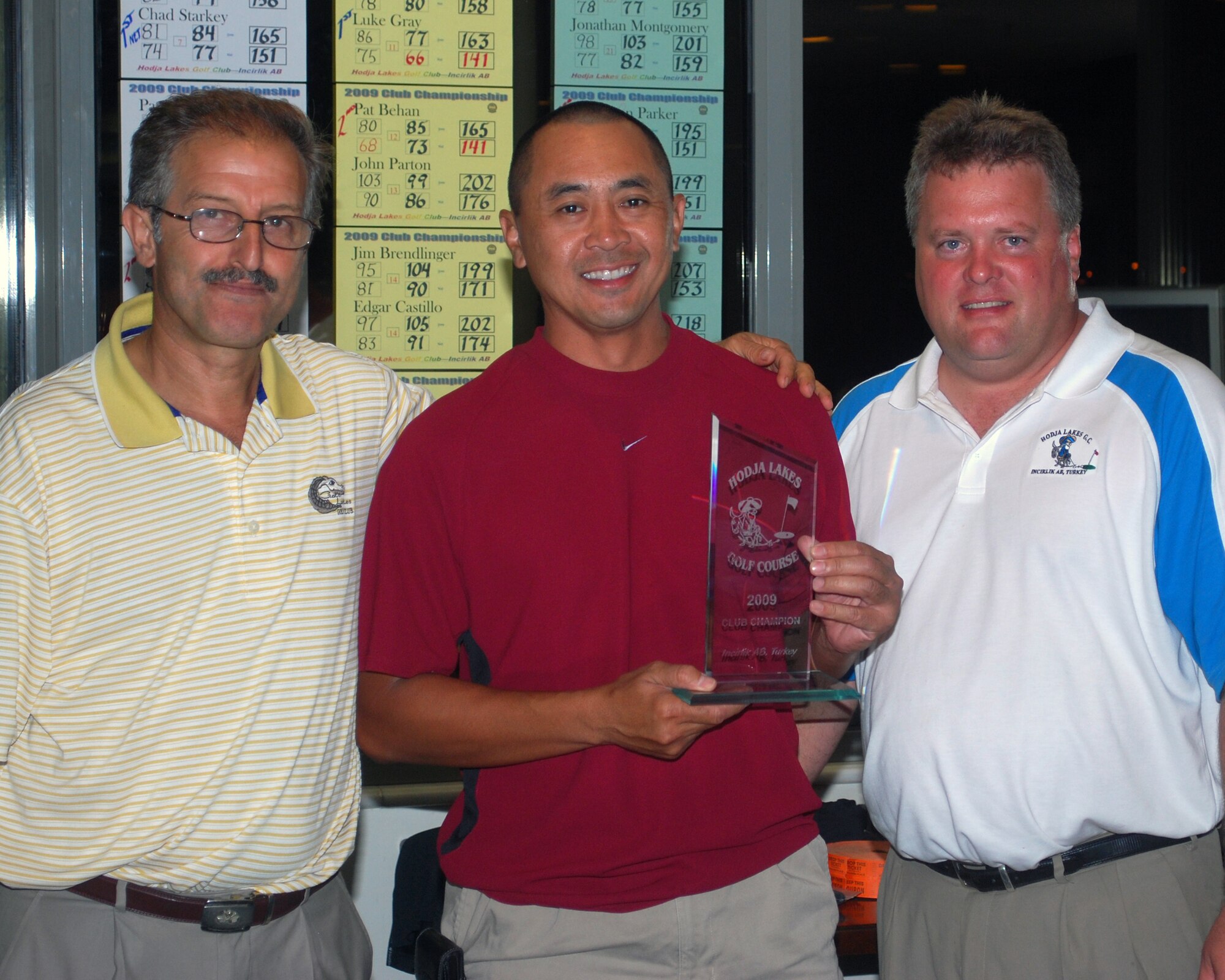 Vachara Landry, 39th Contracting Squadron, holds his trophy after winning the two-day base golf championship by two strokes against field of 32 players Sunday, Sept. 13, 2009, at Hodja Lakes Golf Course, Incirlik Air Base, Turkey. Landry was presented the trophy by Ferhat Monur (left), Golf Course assistant manager, and Tom Abrahamson (right), Golf Course manager.  (U.S. Air Force photo/Col. Lawrence Gray)