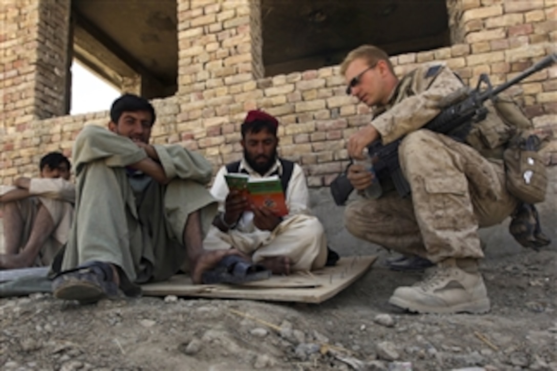U.S. Marine Corps Lance Cpl. Benjamin Lascelles teaches an Afghan man English words in the Nawa district of the Helmand province, Afghanistan, on Sept. 12, 2009.  Lascelles is assigned to Headquarters and Service Company, 1st Battalion, 5th Marine Regiment and is deployed with Regimental Combat Team 3 to conduct counterinsurgency operations in partnership with the Afghan National Security Forces in southern Afghanistan.  